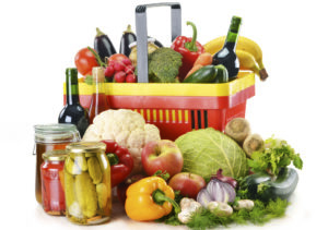 Plastic shopping basket and grocery isolated on white